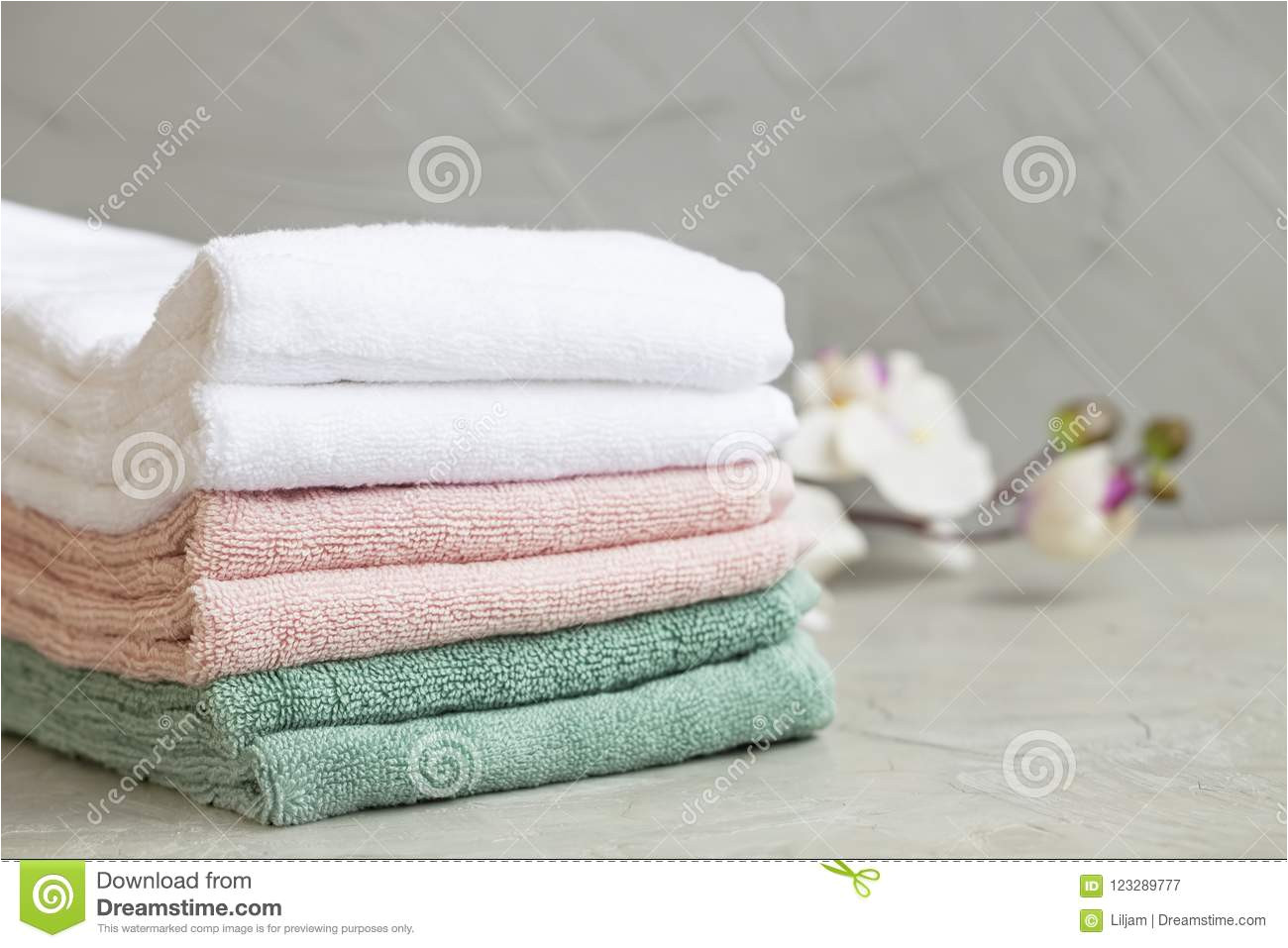 pile of clean cotton bath towels on concrete background laundry or bathroom concept